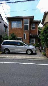 uma carrinha prateada estacionada em frente a uma casa em Homestay Intimo Amigo em Tóquio