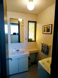 a bathroom with a sink and a mirror and a tub at Homestay Intimo Amigo in Tokyo