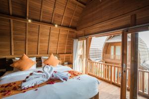 a bedroom with two beds and a balcony at Andi Beach House in Canggu