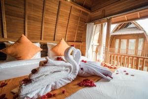 a bedroom with a bed with towels on it at Andi Beach House in Canggu
