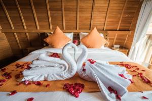 two swans wrapped in towels on a bed at Andi Beach House in Canggu