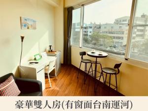 a room with a desk and a table and a window at New Color River in Tainan