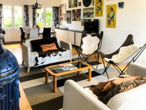 ein Wohnzimmer mit Sofas, Stühlen und einem Tisch in der Unterkunft Résidence Le Lenn-louannec - Maisons & Villas pour 6 Personnes 784 in Lannion