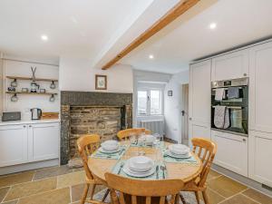 a kitchen and dining room with a table and chairs at Spinners Cottage in Keighley