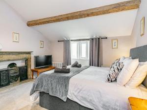 1 dormitorio con 1 cama grande y chimenea en Spinners Cottage en Keighley