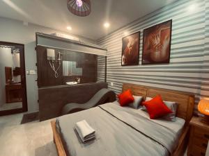 1 dormitorio con 1 cama grande con almohadas rojas en The Grandparents Homestay Full Nguyên Căn en Quy Nhon