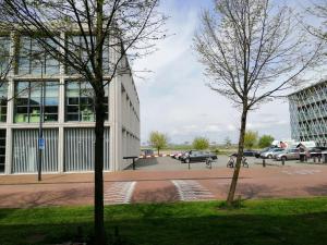 All you need, a comfy place في أمستردام: مبنى فيه سيارات متوقفة في موقف للسيارات