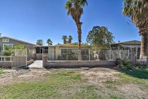 a fence in front of a house with palm trees at Bullhead City Home Close to Laughlin Casinos! in Bullhead City