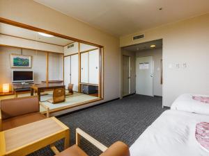 a hotel room with a bed and a desk at KAMENOI HOTEL Yamato Heguri in Heguri