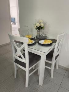 a dining room table with two chairs and a white table with plates at City Center Apartment - Neama Bay in Sharm El Sheikh +4 photos