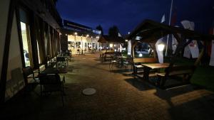 a group of tables and chairs on a street at night at Hotel Galion in Gdańsk