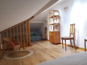 een slaapkamer met een trap, een bed en een stoel bij Maisonnette de Charme à 10min de Fontainebleau in Héricy