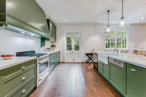 a kitchen with green cabinets and white counter tops at Villa Northcote Luxurious 4BR Wood Fireplace Leura in Leura