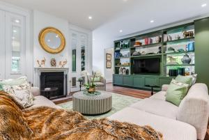 ein Wohnzimmer mit 2 Sofas und einem Kamin in der Unterkunft Villa Northcote Luxurious 4BR Wood Fireplace Leura in Leura