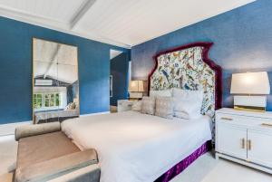 a bedroom with a large bed and blue walls at Villa Northcote Luxurious 4BR Wood Fireplace Leura in Leura