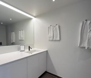 W białej łazience znajduje się umywalka i lustro. w obiekcie STAY Nordhavn w Kopenhadze