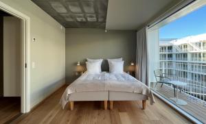 a bedroom with a bed and a large window at STAY Nordhavn in Copenhagen