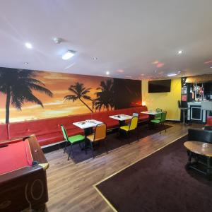 ein Restaurant mit Tischen und Stühlen und einem Gemälde an der Wand in der Unterkunft Las Palmas Hotel by the Sea in Blackpool