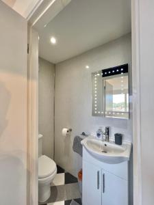 a bathroom with a sink and a toilet and a mirror at Beach Front Apartment with Free Parking, St Annes in Lytham St Annes