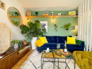 - un salon avec un canapé bleu et des oreillers jaunes dans l'établissement Votre Escale Boule d Or Sauna & Spa, à Niort
