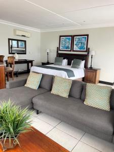 ein Wohnzimmer mit einem Sofa und einem Bett in der Unterkunft Gracelands Beach Lodge in Ramsgate