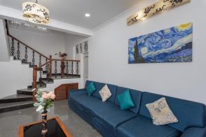 a living room with a blue couch and a painting at 5BHK Villa Calangute Phase 2, just 2 Min walk to Calangute Beach in Arpora +38 photos