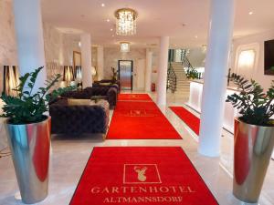 a living room with red carpets on the floor at Gartenhotel Altmannsdorf in Vienna