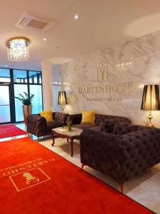 Gartenhotel Altmannsdorf في فيينا: غرفة معيشة مع كنب وسجادة حمراء