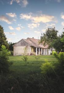 una casa vieja sentada en un campo de hierba en Nálunk, vidéken, en Ásványráró