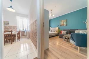 a living room and dining room with blue walls at Apartament Przytulny Starówka Old Town Piwna in Gdańsk