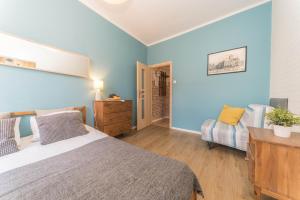 a bedroom with blue walls and a bed and a dresser at Apartament Przytulny Starówka Old Town Piwna in Gdańsk