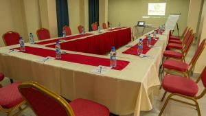 - une grande table avec des chaises et des bouteilles d'eau dans l'établissement Whirlspring Hotel, à Kisumu