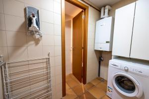 a small laundry room with a washer and dryer at Cal Muntanyà in Puigcerdà