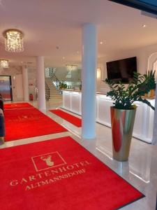 a lobby with red carpets and a vase on the floor at Gartenhotel Altmannsdorf in Vienna
