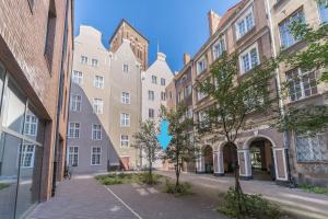 een rij gebouwen op een straat met bomen bij Apartament Przytulny Starówka Old Town Piwna in Gdańsk