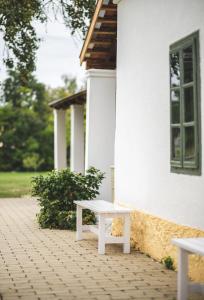 ÁsványráróにあるNálunk, vidékenの白い建物の外に座る白いベンチ