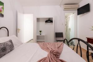 una camera da letto con un letto bianco con una coperta rosa di Zante Riva Studios a Lithakia Altre 23 foto
