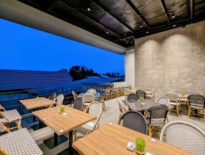 an outdoor patio with wooden tables and chairs at Grand Zuri Lubuklinggau in Lubuklinggau