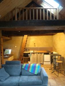 een woonkamer met een blauwe bank en een loft bij Chaleureuse maisonnette in Lopérec