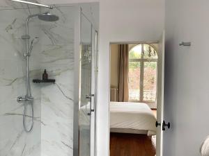 Baño con ducha a ras de suelo junto a una cama en Domaine de Bonneuil, en Bonneuil-les-Eaux
