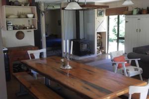 uma sala de estar com uma mesa de madeira e uma lareira em Cosy Country Cottage - Outdoor Pizza Oven - Rural Setting on 4 Acres em Raetihi