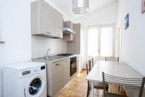 une cuisine avec une machine à laver et une table dans l'établissement Appartamenti Scaglieri, à Portoferraio