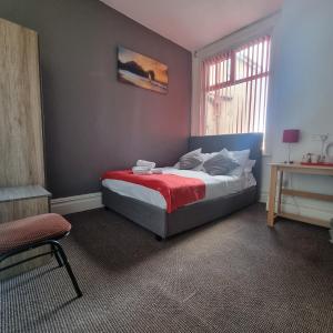 ein Schlafzimmer mit einem Bett mit einer roten Decke in der Unterkunft Las Palmas Hotel by the Sea in Blackpool