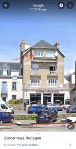 a building with cars parked in front of it at La touline in Concarneau