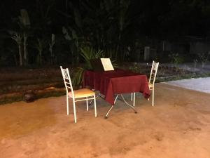 2 chaises et une table avec un livre. dans l'établissement Bee lucky homestay cat ba Island, à Xuan Dam