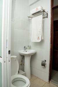 La salle de bains blanche est pourvue de toilettes et d'un lavabo. dans l'établissement Whirlspring Hotel, à Kisumu