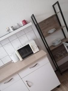eine Küche mit weißen Schränken und einer Mikrowelle in der Unterkunft Ferienwohnung Poehlmann in Plauen