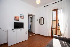 un salon avec une télévision sur un mur blanc dans l'établissement Appartamenti Scaglieri, à Portoferraio