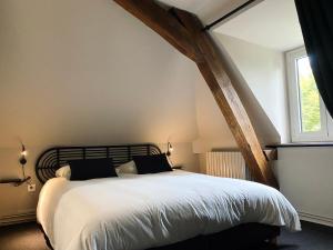 1 dormitorio con 1 cama grande con sábanas blancas y ventana en Domaine de Bonneuil en Bonneuil-les-Eaux