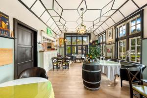 een restaurant met tafels en stoelen en een groot plafond bij Hotel Kasteelhof 'T Hooghe in Ieper